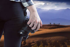 专业摄影师或业余爱好者带着相机在沙漠中旅行。这个视图是设备的缩影，所以把摄影描绘成一种户外活动