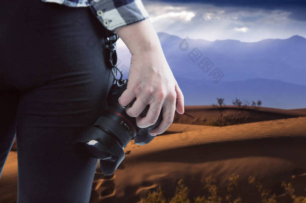 专业摄影师或业余爱好者带着相机在沙漠中旅行。这个视图是设备的缩影，<strong>所以</strong>把摄影描绘成一种户外活动