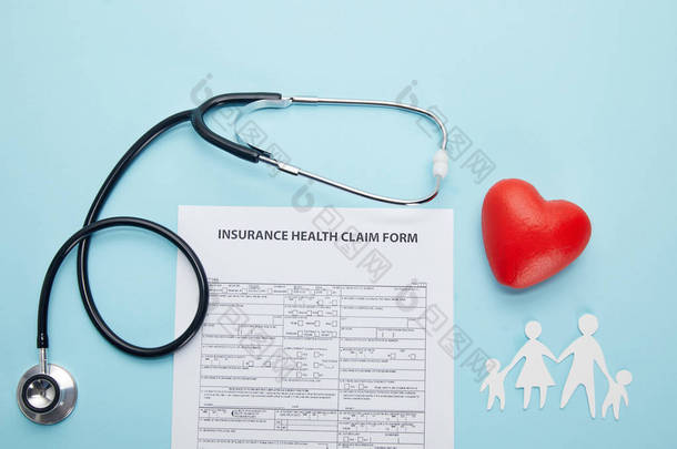 保险健康索赔表单, 剪纸家庭, 红色心脏符号和听诊器在蓝色的顶部视图 