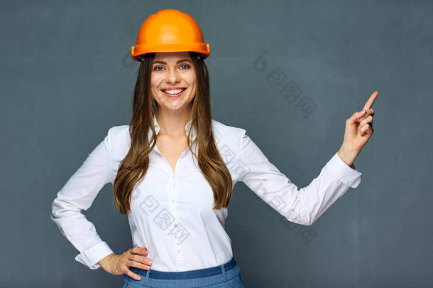 微笑的妇女建设者工程师指点手指在拷贝空间 