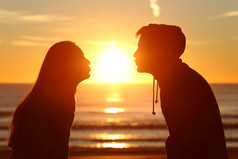 情侣接吻与爱在日落时太阳