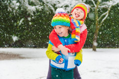 孩子们在下大雪，公园里玩的颜色鲜艳的衣服穿着彩色针织物