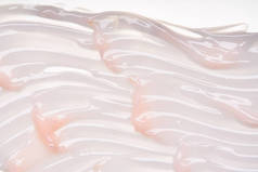 柔和的粉红色奶油纹理在白色背景下分离。白底面霜涂抹