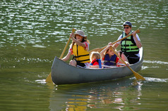 在湖中划独木舟的家庭