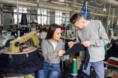 在纺织工业中，一对年轻男女在织机上分析针织工作的特写照片