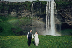 已婚妇女和男子走近瀑布在白天