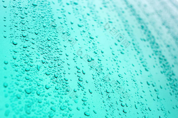 蓝色背景上的雨滴.夏天的雨滴闭包视图.