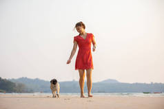 狗只在海滩上奔跑，主人很开心，很快乐，狗只度假的概念