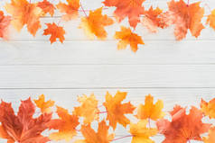 在木质表面上的橙色秋季枫叶的高视图