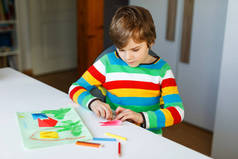 小男孩为母亲节或生日的明信片做纸制折纸、折纸、郁金香花。孩子们在家上学的时候，在考罗内维耶斯围产期，学校都关门了。家庭教育的概念