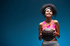 穿着运动服的快乐女人,手握蓝衣打篮球