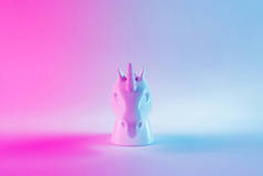 白色画的独角兽头在大胆的粉红色和蓝色的霓虹灯颜色梯度背景。最小的艺术幻想概念.