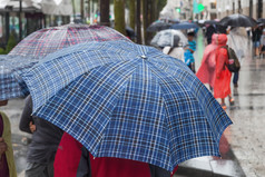 在多雨的城市雨遮阳伞的人
