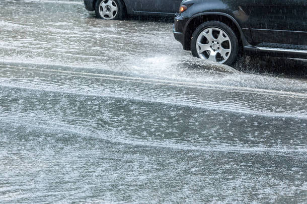 城市道路上的大水坑。大雨中的汽车<strong>交通</strong>