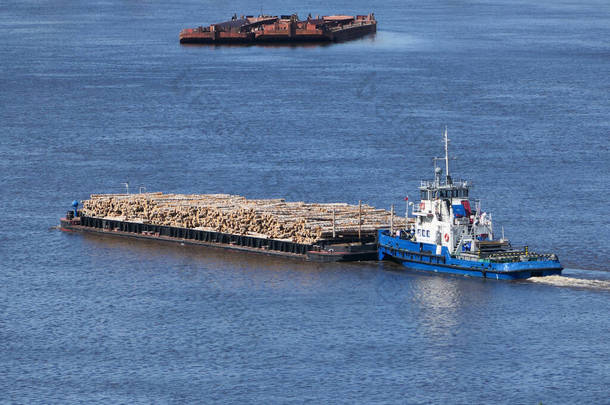 夏天，这艘驳船<strong>沿河</strong>运送货物和木料.