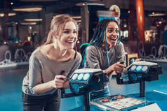 两个女人站在平台上玩电子游戏. 