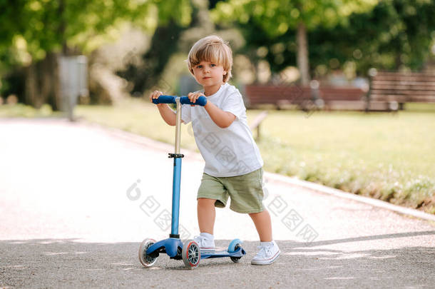 在阳光明媚的<strong>夏日</strong>，男孩在公园里学习骑摩托车。学龄前男孩骑着滚筒。孩子们在<strong>户外</strong>玩摩托车。儿童的积极休闲活动和<strong>户外</strong>运动.