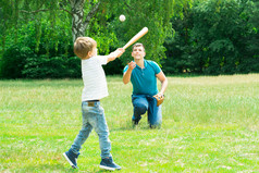 小男孩打球，他的父亲