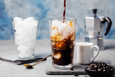 高玻璃杯中的冰咖啡和咖啡豆