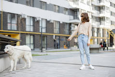 女人和她的大白狗在街上散步
