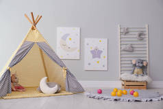 用可爱的绘画和游乐帐篷装饰着时髦的儿童房