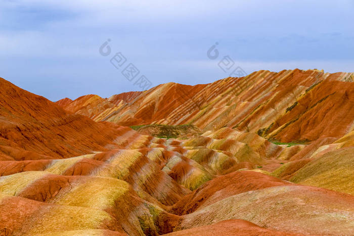 彩虹山迷人的风景和夕阳西下的蓝天背景.中国甘肃张业丹霞国家地质公园。五彩缤纷的风景，彩虹的山丘，不同寻常的彩色岩石，砂岩的侵蚀