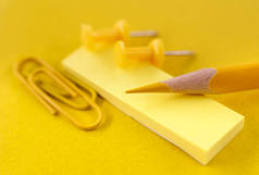 一支黄色的铅笔放在剪贴簿上，上面有剪纸夹