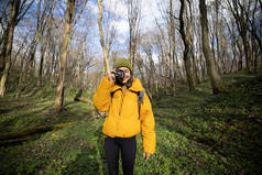 森林里穿着远足服装、拿着相机的女人
