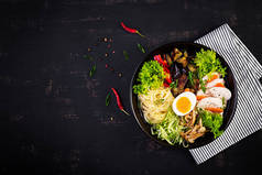 日本拉面汤与鸡，鸡蛋，香菇和茄子在黑暗的木制背景。香子纳贝，相扑汤。顶部视图