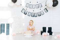 生日女孩1岁坐在靠近生日蛋糕的照片区