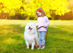 快乐积极的小女孩和狗在户外玩得开心 