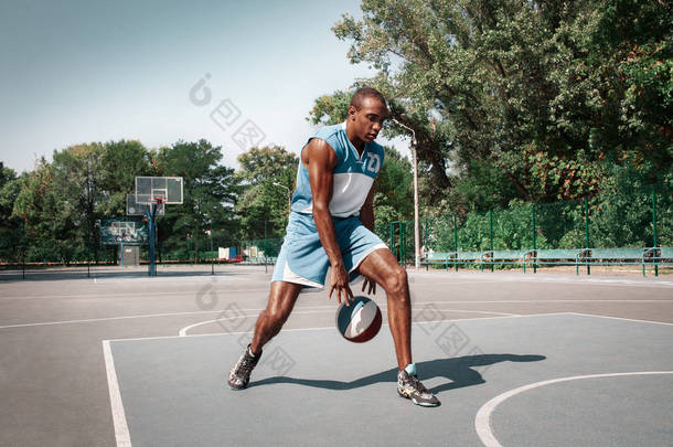 年轻混乱的非洲篮球运动员在户外练习的图片。适合非洲人的运动和运动。运动和体育生活方式概念