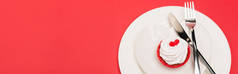 顶部视图盘中的纸杯蛋糕与餐具红色背景，横幅
