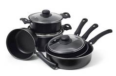 一套白色背景的黑色不粘厨房用具。锅子,勺子,平底锅,玻璃罩.