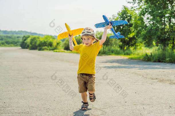 快乐的孩子玩玩具飞机与老跑道背景。带孩子旅行的概念