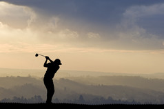 对令人惊叹的夕阳的天空高尔夫球手剪影