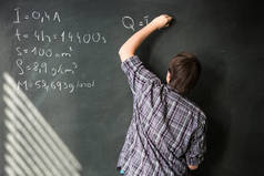 大学生在数学课在黑板前，在解决数学问题 