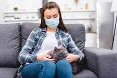 戴着医疗口罩的女孩抱着猫, 在家中患有过敏症  