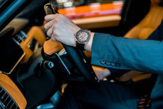 裁剪的商人与豪华手表坐在汽车的形象