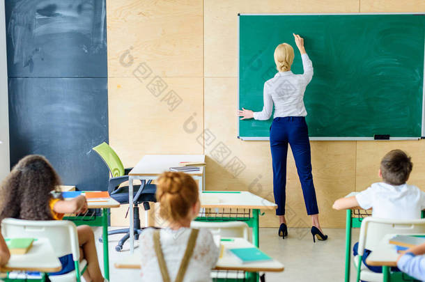 <strong>学生</strong>看老师的后视图, 而她在<strong>黑板</strong>上写字