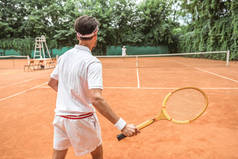 网球赛场上网球与木球拍的运动员后视