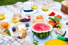 在意大利花园的绿草上的夏日野餐篮。食物和饮料概念。朋友聚会时间