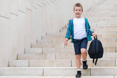 在去学校的路上，一个提着背包的学童走下楼梯。回学校去.