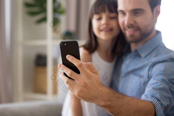 父亲和女儿使用智能手机制作自拍摄影