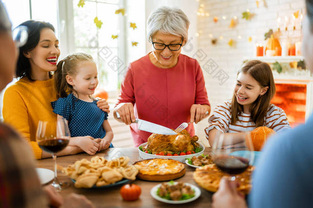 <strong>感恩节</strong>快乐！秋天的宴会。一家人坐在桌旁<strong>庆祝</strong>节日.祖父母、母亲、父亲和子女。传统的晚餐.