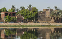 埃及埃德福河上的尼罗河大对岸, 通过农村乡村景观, 河岸上有非洲房屋