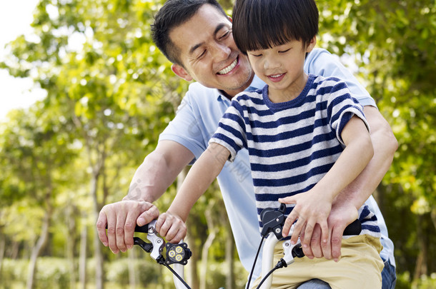 亚洲的父亲和儿子享受户外<strong>骑自行车</strong>
