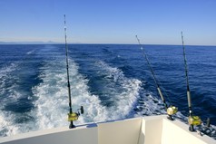 渔杆和卷筒上的船，在蓝色的海洋捕捞