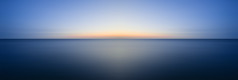 长时间曝光的海景图片风平浪静的大海，令人惊叹的日落时分