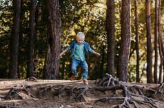 一个快乐快乐的小男孩在公园里散步的时候，跟在一个朋友后面笑着。 快乐的童年 夏天的时间。 暑假。 积极的情绪和精力